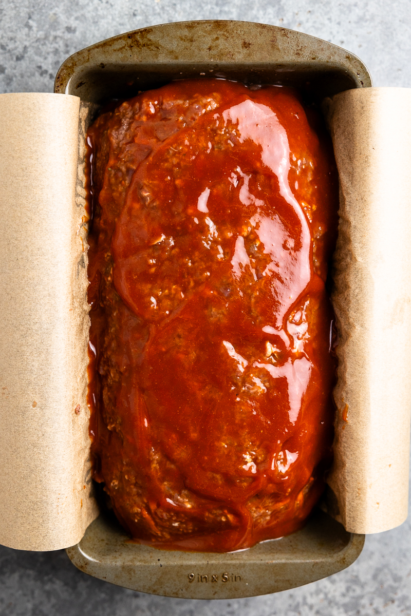 Meatloaf pressed into a loaf pan and brushed with a ketchup glaze