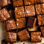 brownies on a cutting board sliced into 16 pieces with one brownie turned on it's side