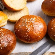 hamburger buns laying next to a bread knife