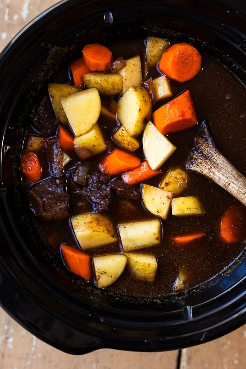Venison stew ingredients such as venison, carrots and potato in a slow cooker.