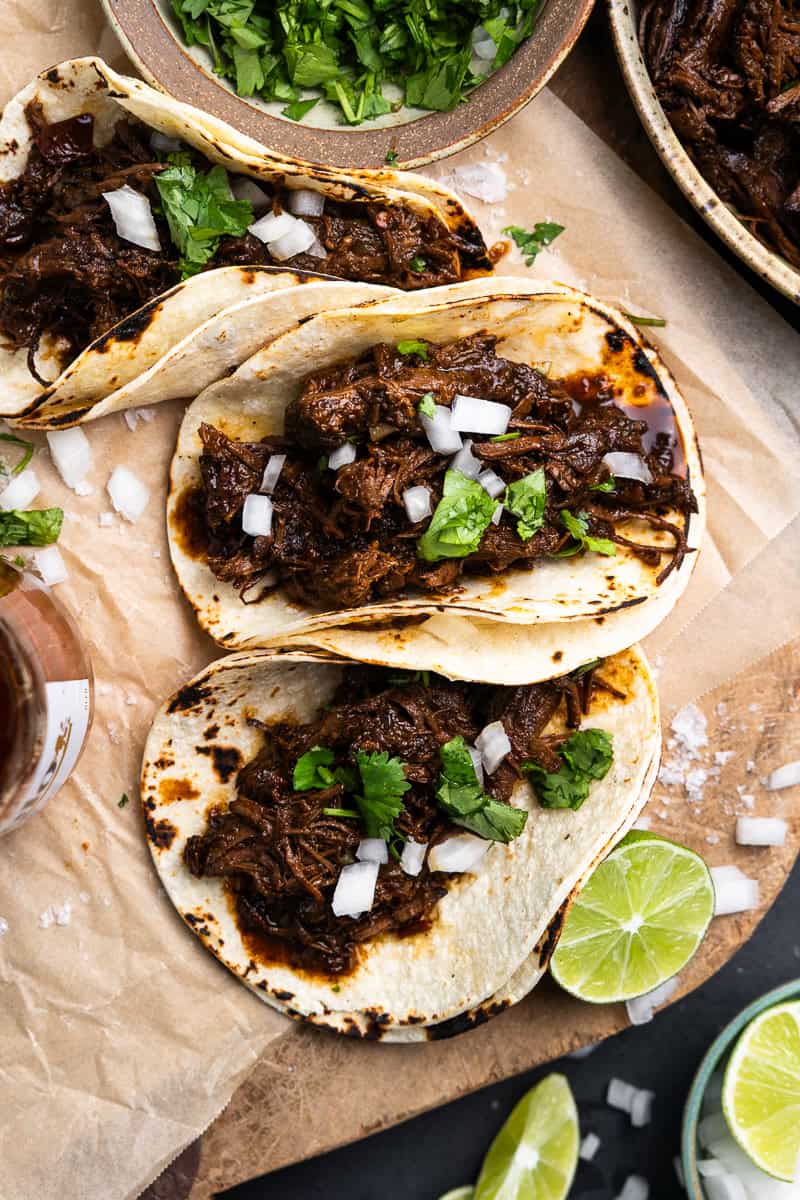 Mexican shredded venison in tortillas, garnished with diced onion and chopped cilantro.