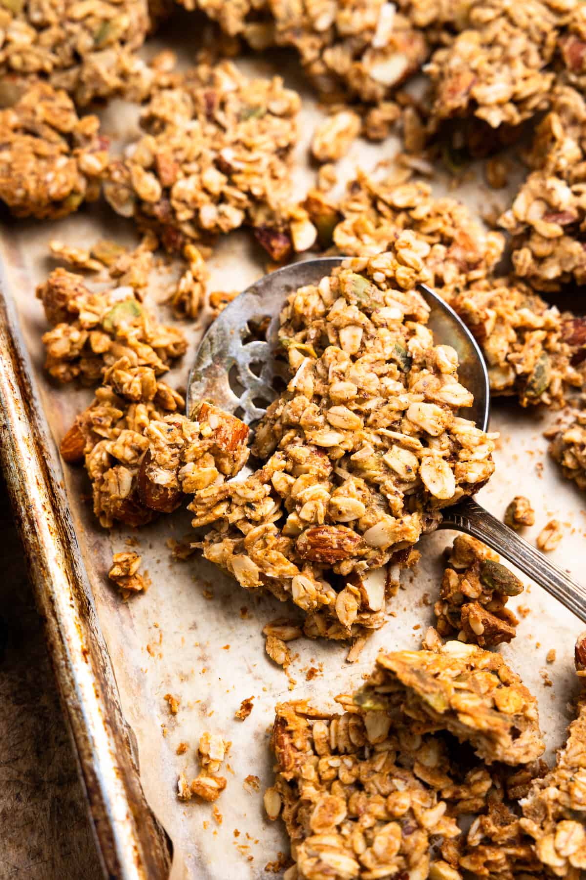 Scooping a big cluster of granola with a spoon.
