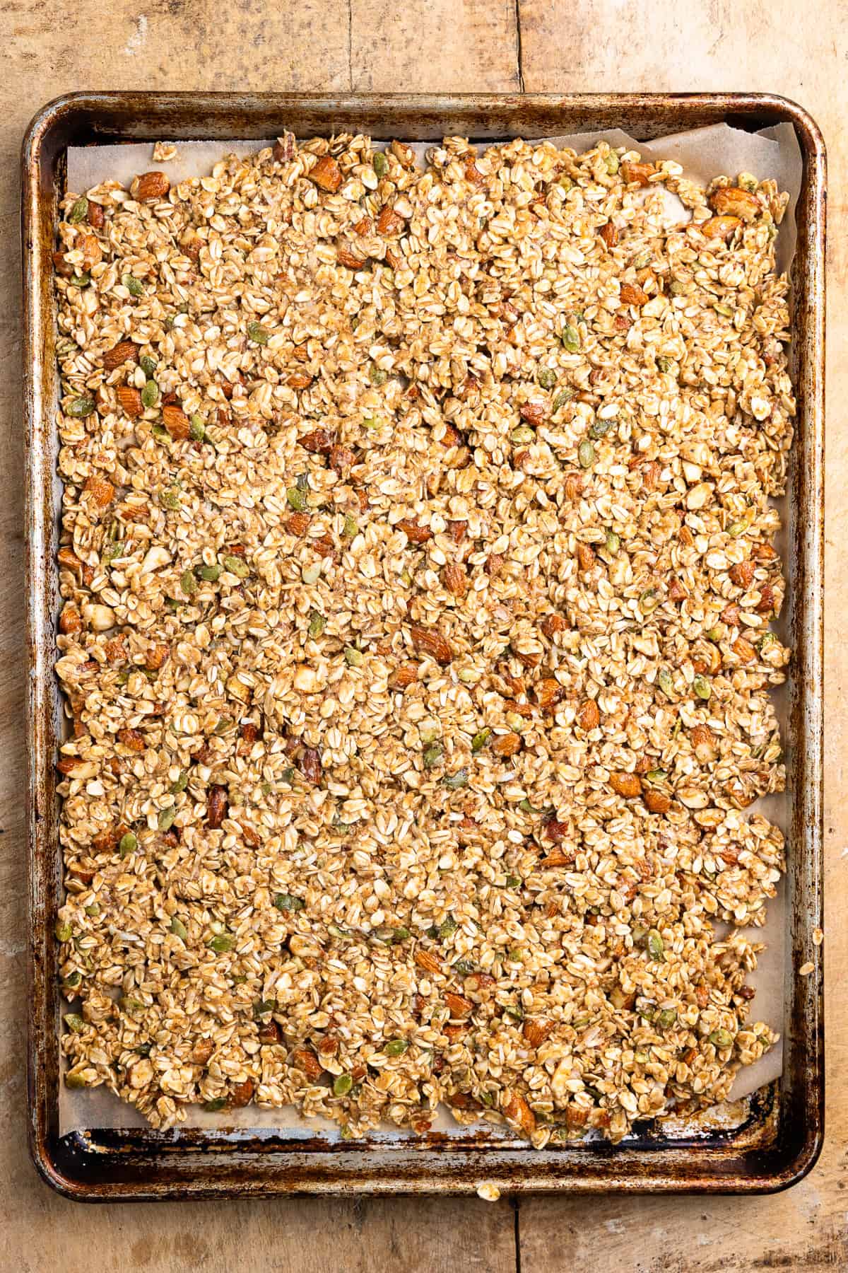Granola mixture pressed out on a sheet pan.