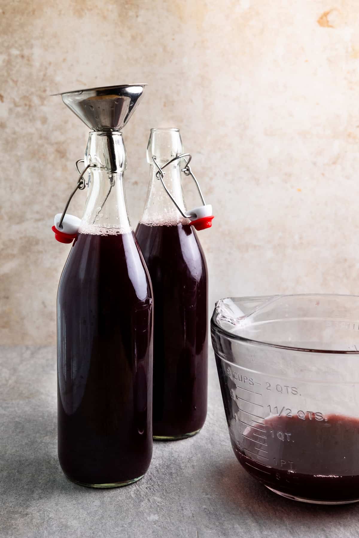 Grape juice and whey poured into two swing top bottles.