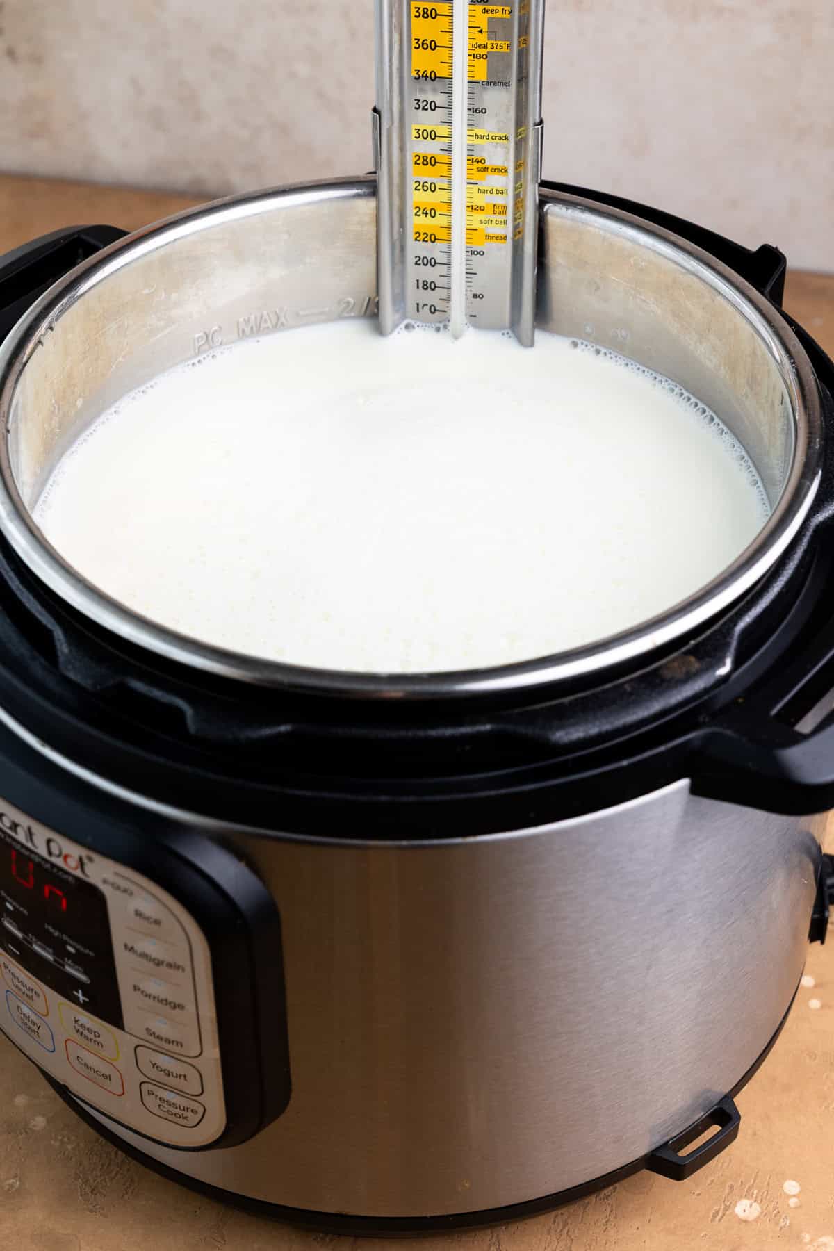 Heating milk in an Instant Pot with a thermometer in the milk.