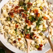 Creamy dill pickle pasta salad in a bowl and garnished with fresh dill and bacon.