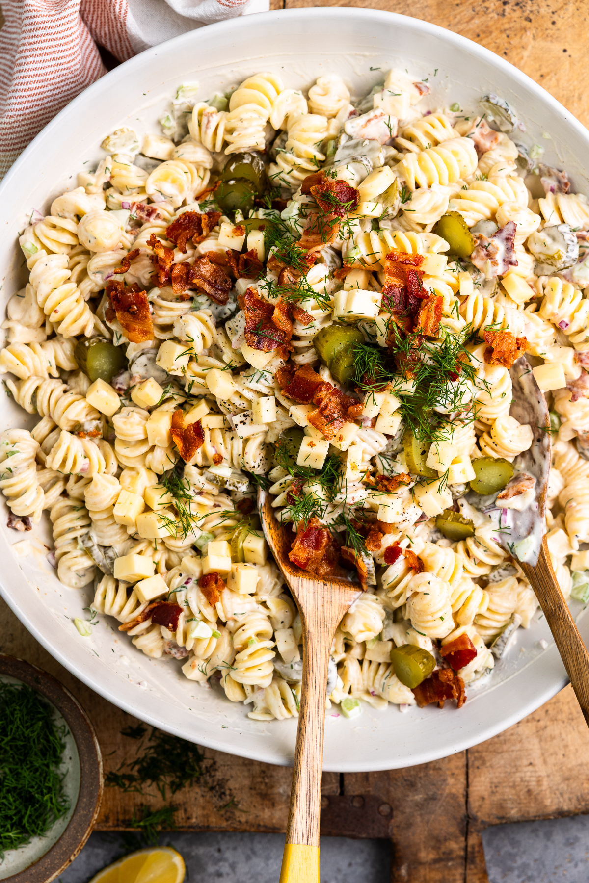 Creamy dill pickle pasta salad in a bowl and garnished with fresh dill and bacon.